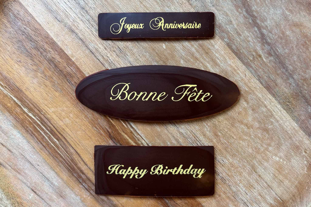 Inscription bonne fête et happy birthday sur une plaque en chocolat