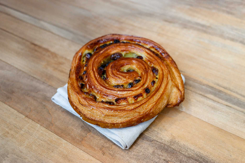 Le roulé aux raisins ou "pain aux raisins" est une viennoiserie composée de pâte feuilletée, crème pâtissière et raisins secs.